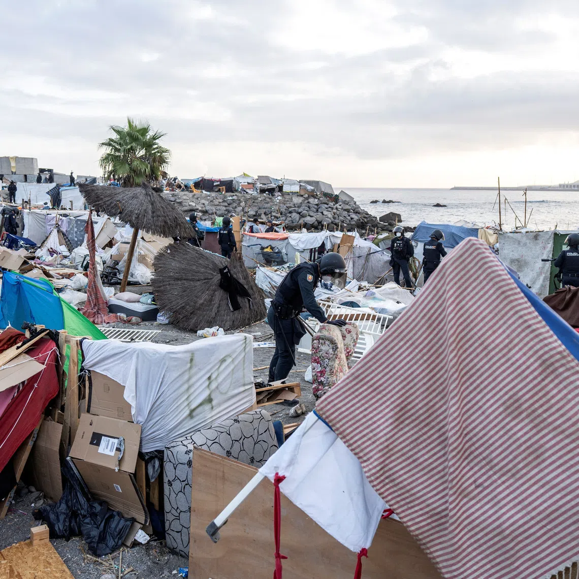 Riot police officers clear part of the makeshift migrant camp at Benitez beach during an operation that, according to police, aims to establish a security perimeter around Ceuta's desalination plant, following the mass crossing of migrants from Morocco, in Ceuta, Spain, September 27, 2026. REUTERS/Manu Brabo