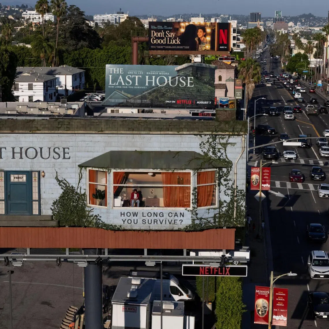 A drone view shows a man inhabiting a billboard on Sunset Boulevard to promote the Netflix film, "The Last House", in Los Angeles, California, U.S., August 7, 2026. REUTERS/Daniel Cole