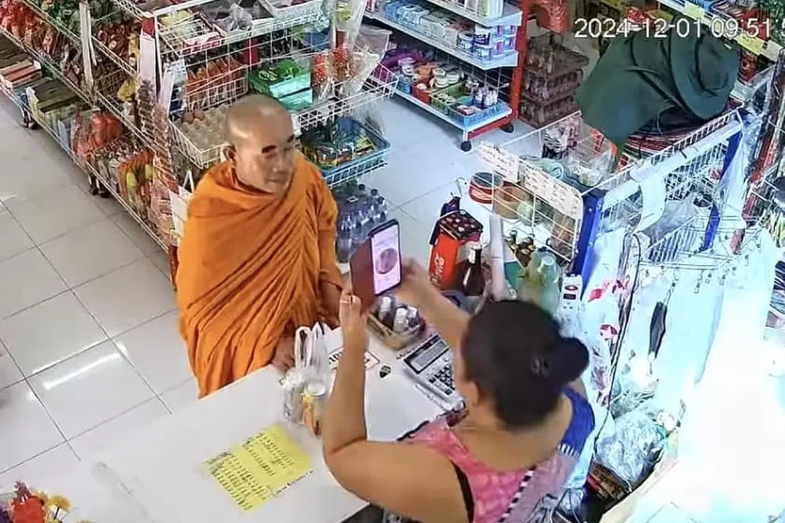The monk having his face, complete with stick-on eyebrows, scanned to access his welfare rights.