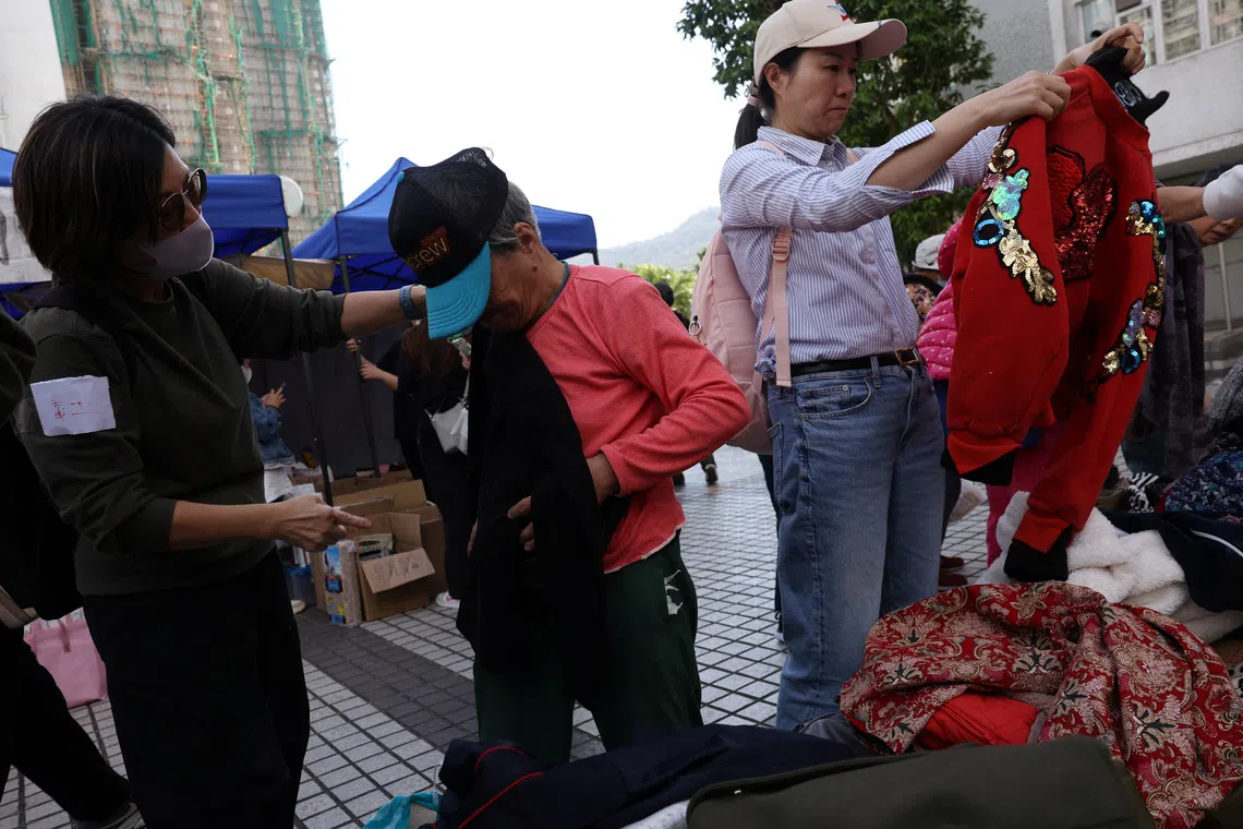 A volunteer helps an elderly resident affected by the deadly fire at the Wang Fuk Court housing complex, at a support station nearby in Hong Kong, China November 28, 2025. REUTERS/Amr Alfiky