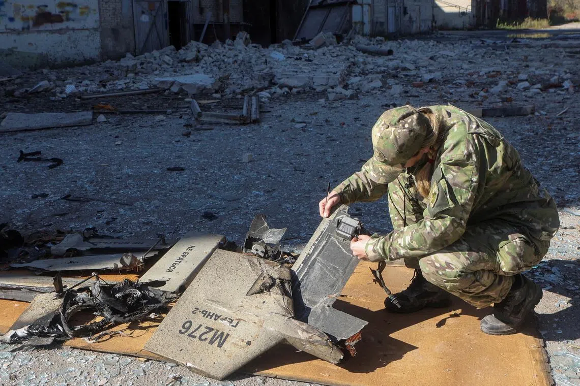 A police officer inspecting parts of a UAV which Ukrainian authorities consider to be an Iranian Shahed-136 suicide drone, in Kharkiv, Ukraine, on Oct 6, 2022. 