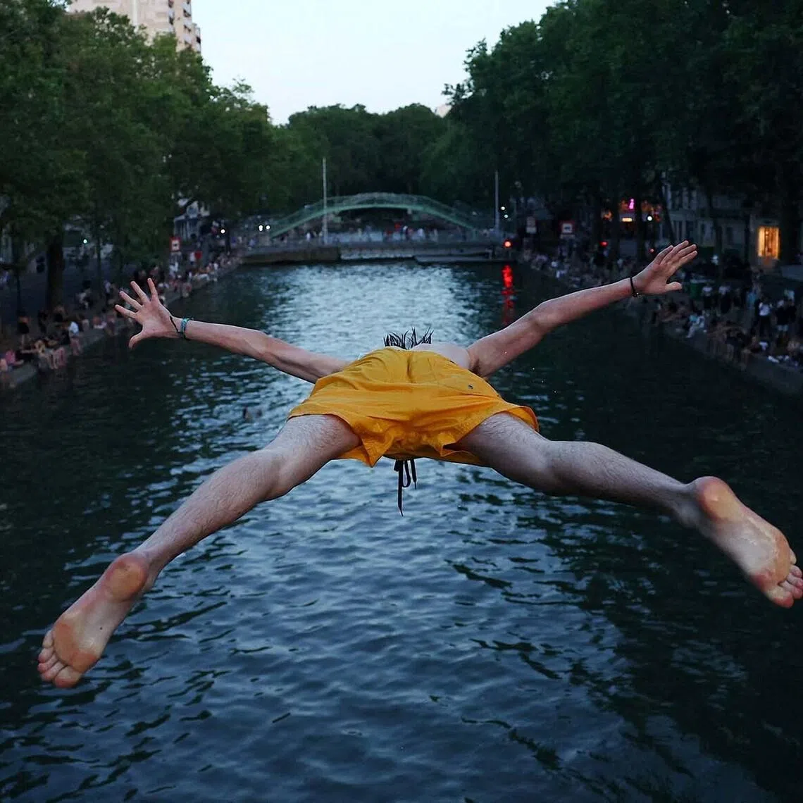 A man diving into the water in the Canal Saint-Martin as temperatures rise during a heatwave affecting a large part of the country, in Paris, France, on June 22.