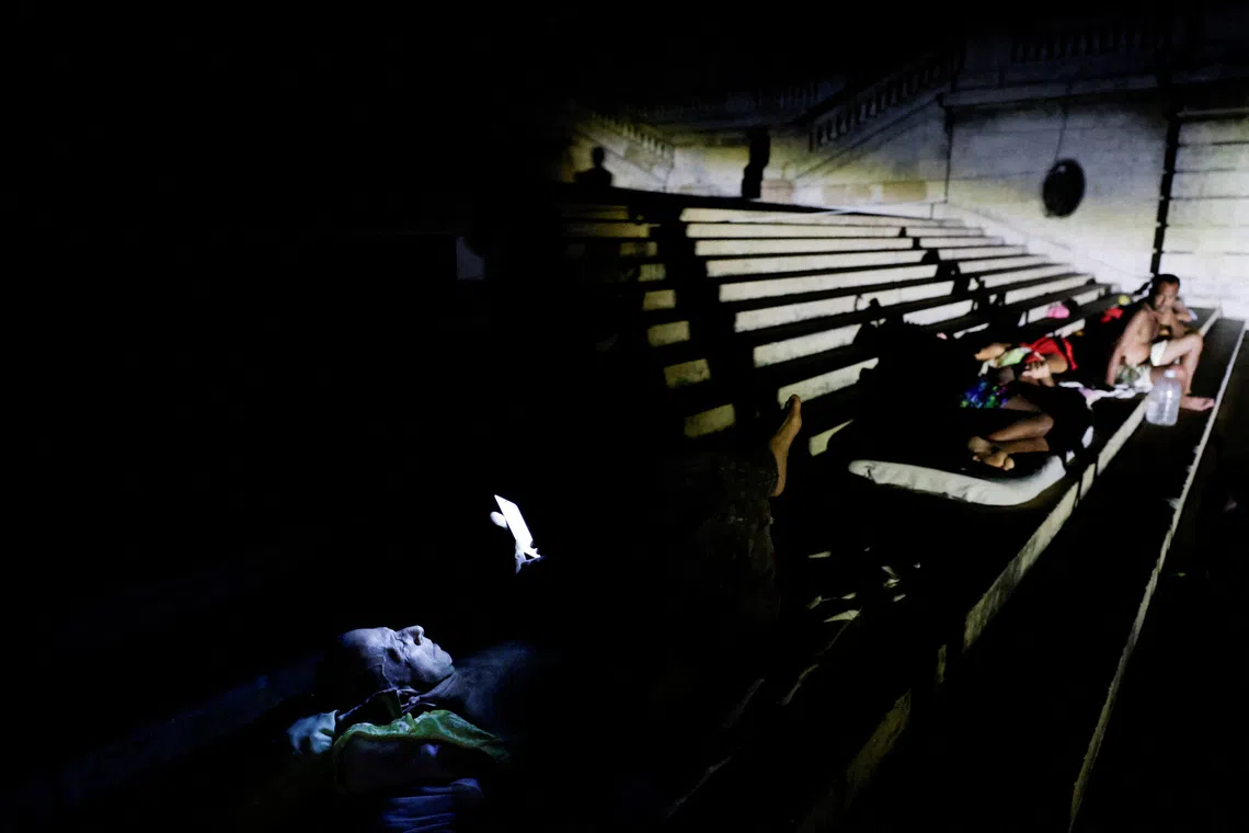 People seated in a dimly lit, tiered indoor amphitheater.