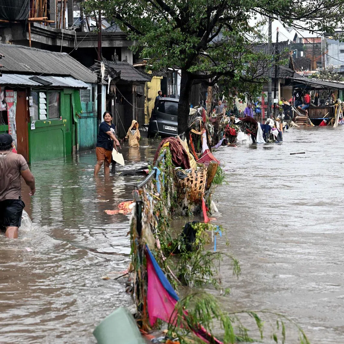 Residents wading through flood waters after heavy rain in Bali on Sept 10. 