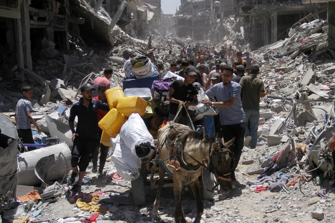 Palestinians make their way, as they inspect the damage after Israeli forces withdrew from Jabalia refugee camp, following a raid, in the northern Gaza Strip, May 31, 2024. REUTERS/Mahmoud Issa/File Photo