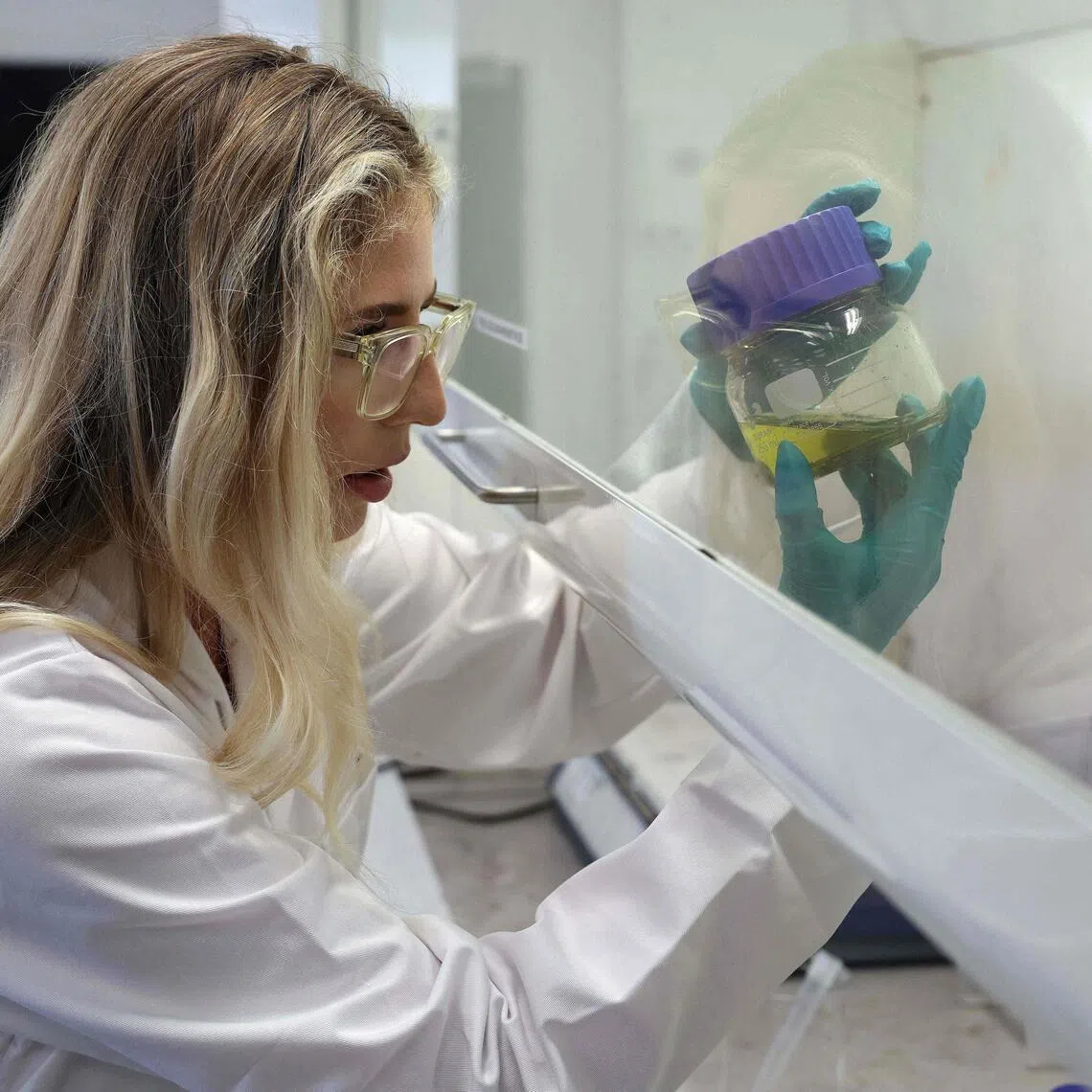 Chemical analyst Kate Griffiths dissolving an electronic component in chemicals to remove the gold at the Royal Mint in Llantrisant, Wales on June 30.