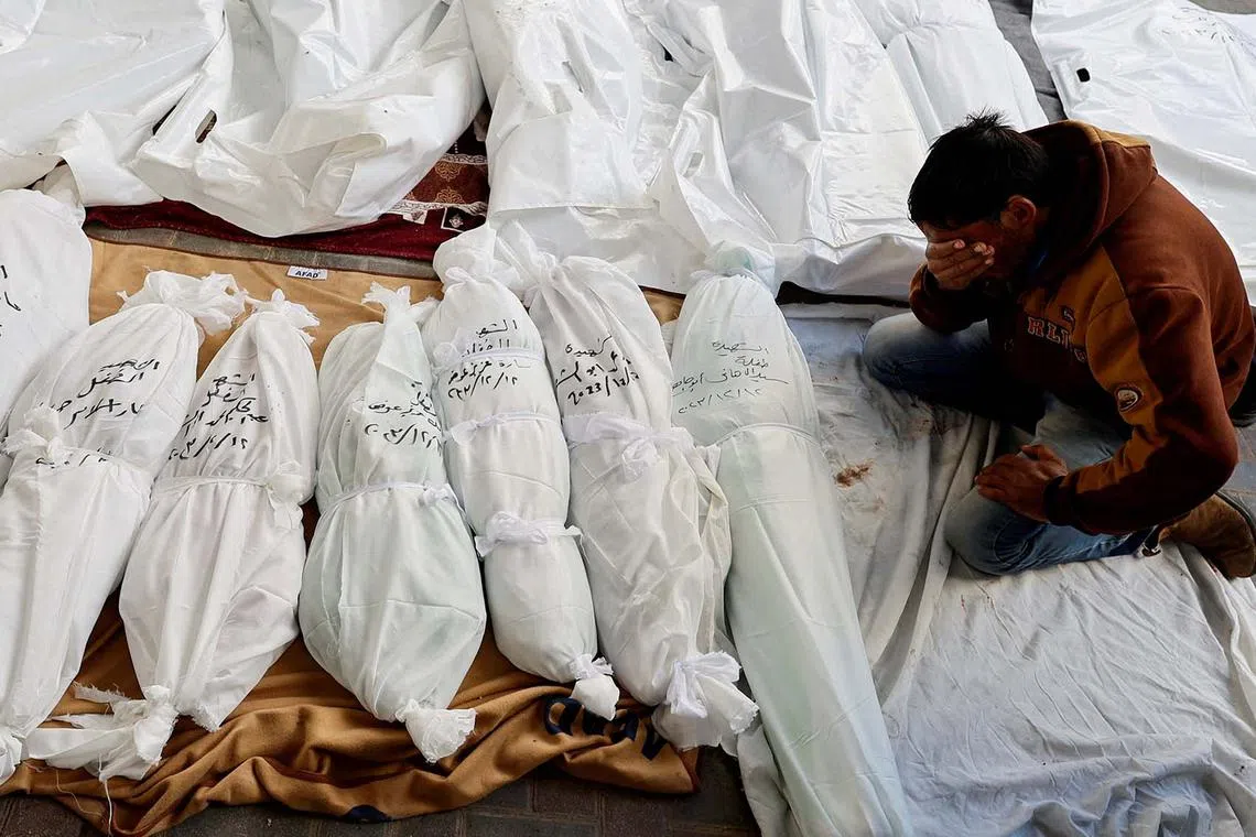 A mourner reacts next to the bodies of Palestinians killed in Israeli strikes, amid the ongoing conflict between Israel and the Palestinian Islamist group Hamas, at Abu Yossef Al-Najar hospital, in Rafah in the southern Gaza Strip December 12, 2023. REUTERS/Mohammed Salem TPX IMAGES OF THE DAY
