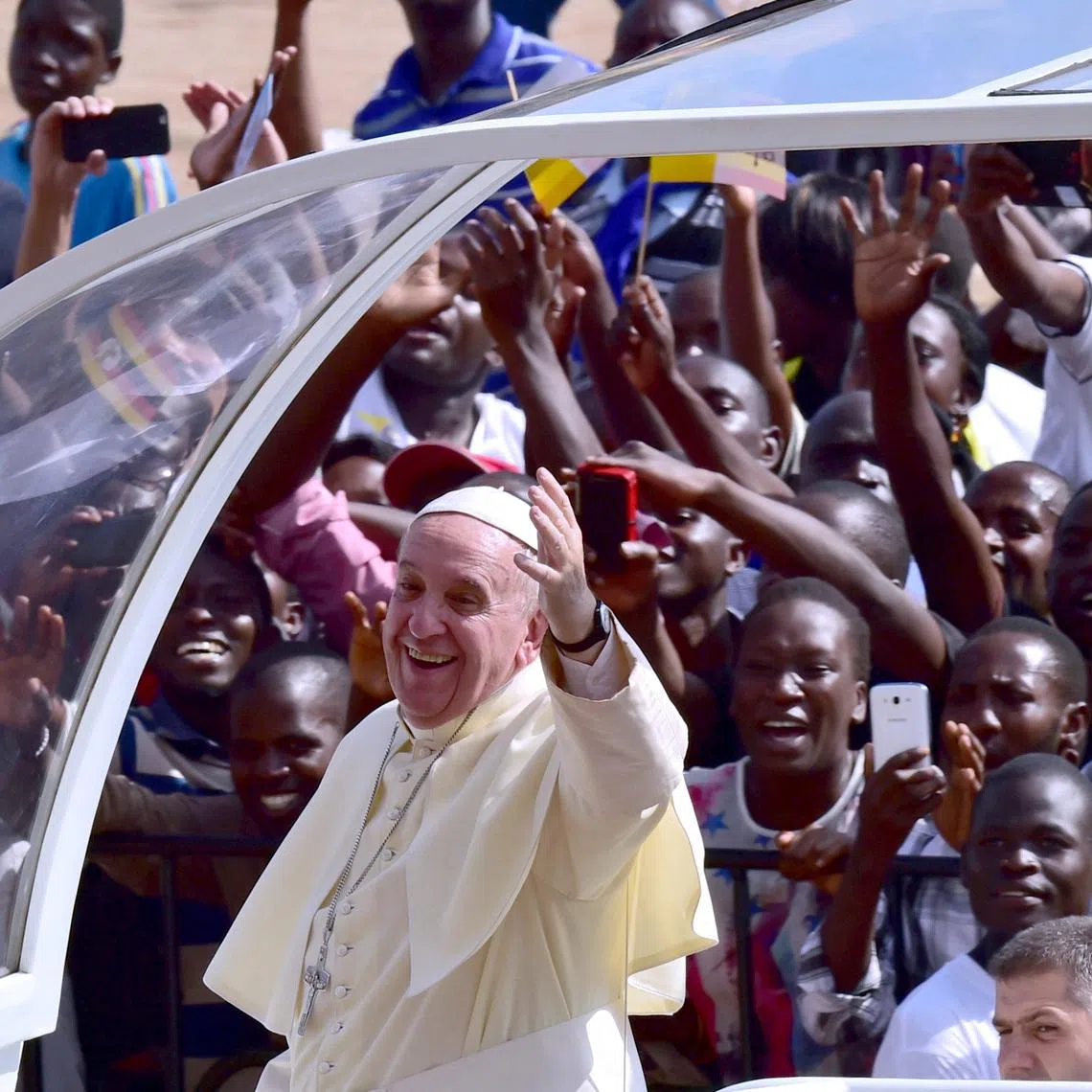 FILE PHOTO: Crowds cheer as Pope Francis arrives at Kololo airstrip in Kampala, November 28, 2015. Pope Francis left Kenya for Uganda where he will spend two days before continuing on to Central African Republic, a country wracked by sectarian conflict. REUTERS/Giuseppe Cacace/Pool/File Photo