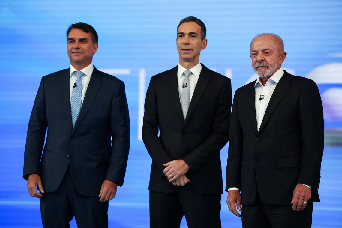 Image 3: Brazilian right-wing presidential candidate Flavio Bolsonaro of the Liberal Party (PL) and leftist President Luiz Inacio Lula da Silva of the Workers’ Party (PT), who is seeking reelection, attend a televised debate with moderator Cesar Tralli ahead of the presidential election runoff in Rio de Janeiro, Brazil, October 23, 2026. REUTERS/Agustin Marcarian