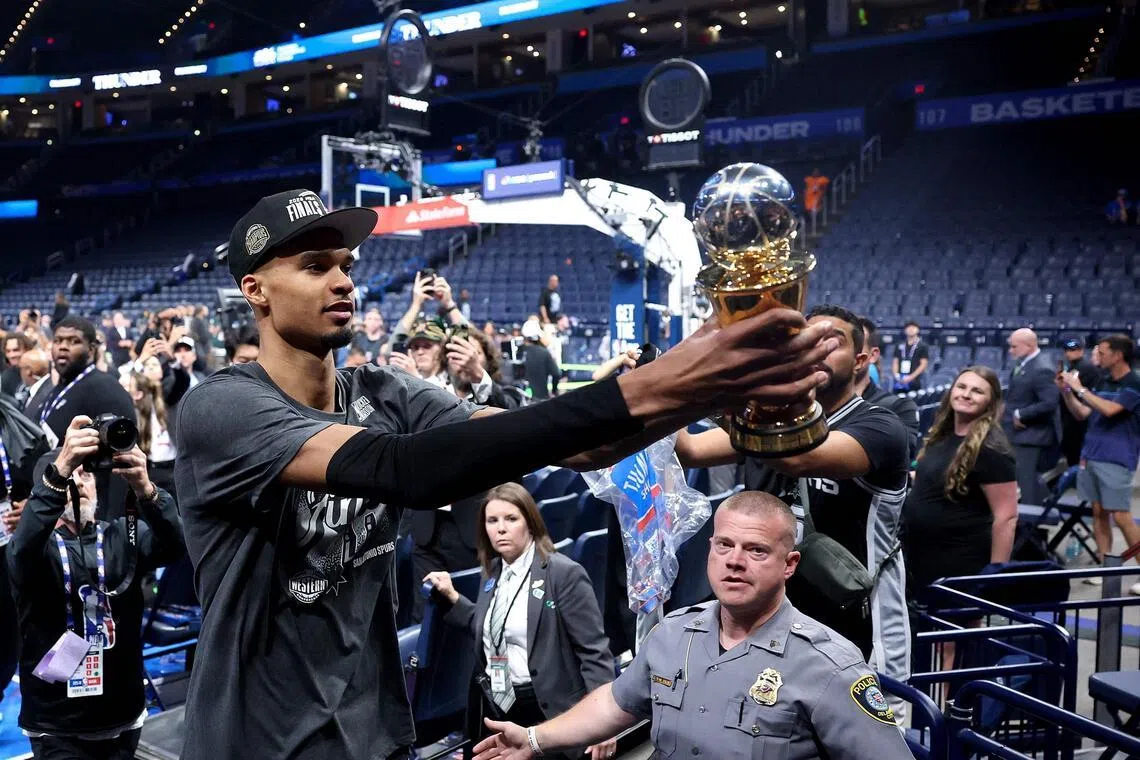Victor Wembanyama of the San Antonio Spurs shows fans the Earvin "Magic" Johnson MVP Trophy after defeating the Oklahoma City Thunder in Game 7 of the NBA Western Conference Finals at Paycom Center.