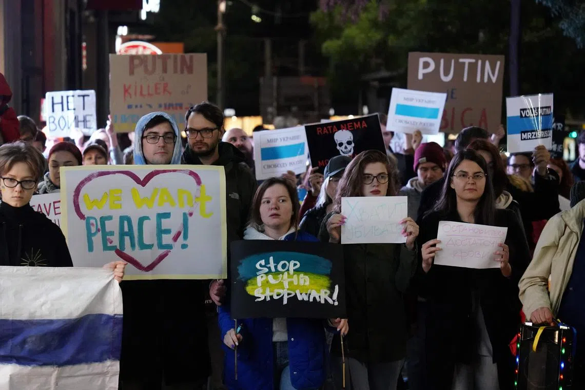 TOPSHOT - People hold anti-war banners during a protest in Belgrade on September 21, 2022, after Russia President dramatically escalated his seven-month war in Ukraine by calling up 300,000 military reservists. (Photo by OLIVER BUNIC / AFP)
