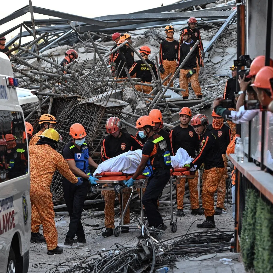 Rescue workers retrieve the body of a victim among debris as a nine-story building under construction collapsed in Balibago, Angeles City, Pampanga, Philippines, May 24, 2026. REUTERS/Noel Celis