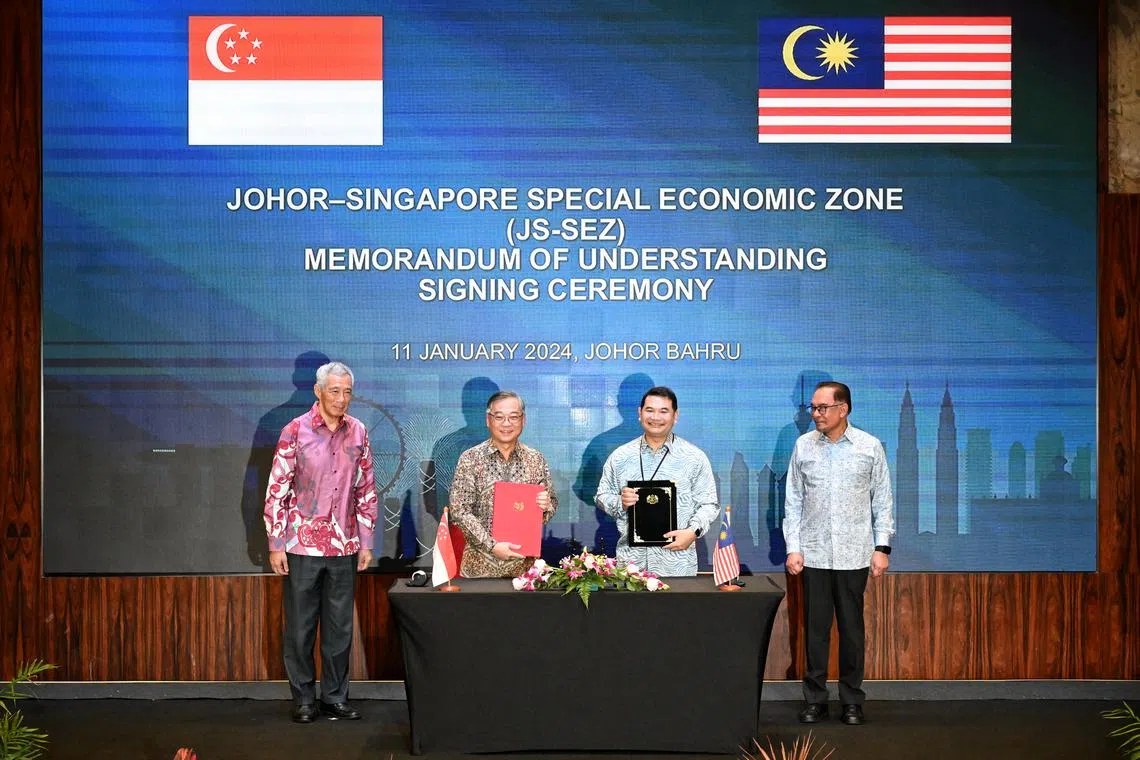 PM Lee Hsien Loong (left) and Malaysian PM Anwar Ibrahim (fourth from left) witnessing the signing of the MOU to work on the JSSEZ by Trade and Industry Minister Gan Kim Yong and Malaysian Minister of Economy Mohd Rafizi Ramli.