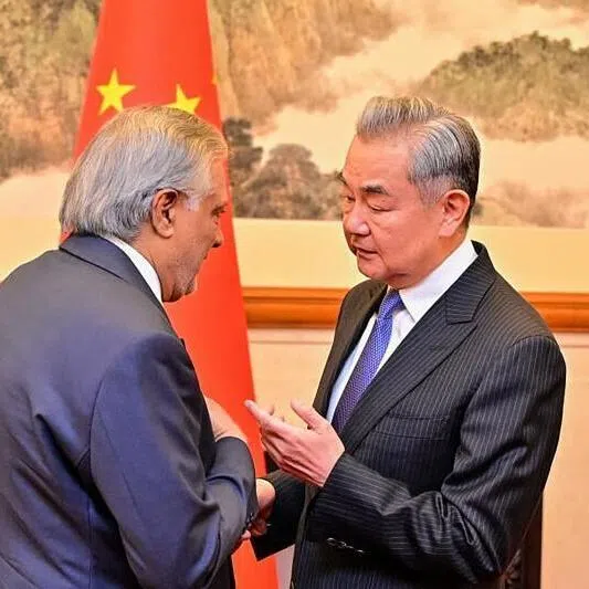 China's Foreign Minister Wang Yi (right) speaking with his Pakistani counterpart Ishaq Dar in Beijing on March 31. China and Pakistan will "strengthen" their cooperation on Iran and hope to push a peace plan through.