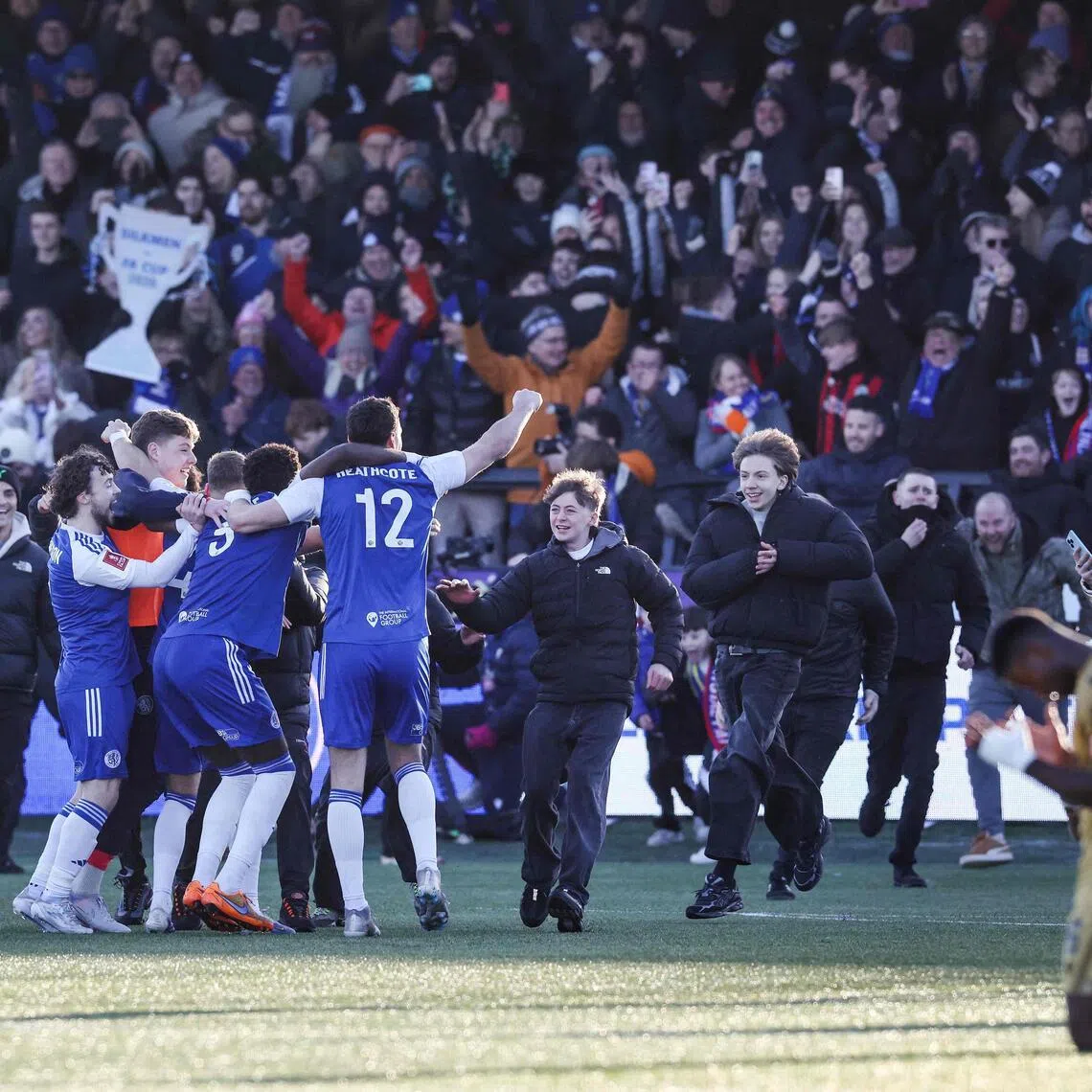 Macclesfield supporters storming the pitch to celebrate the team's 2-1 victory over holders Crystal Palace in the FA Cup third round football match at Leasing.com Stadium on Jan 10, 2026. 