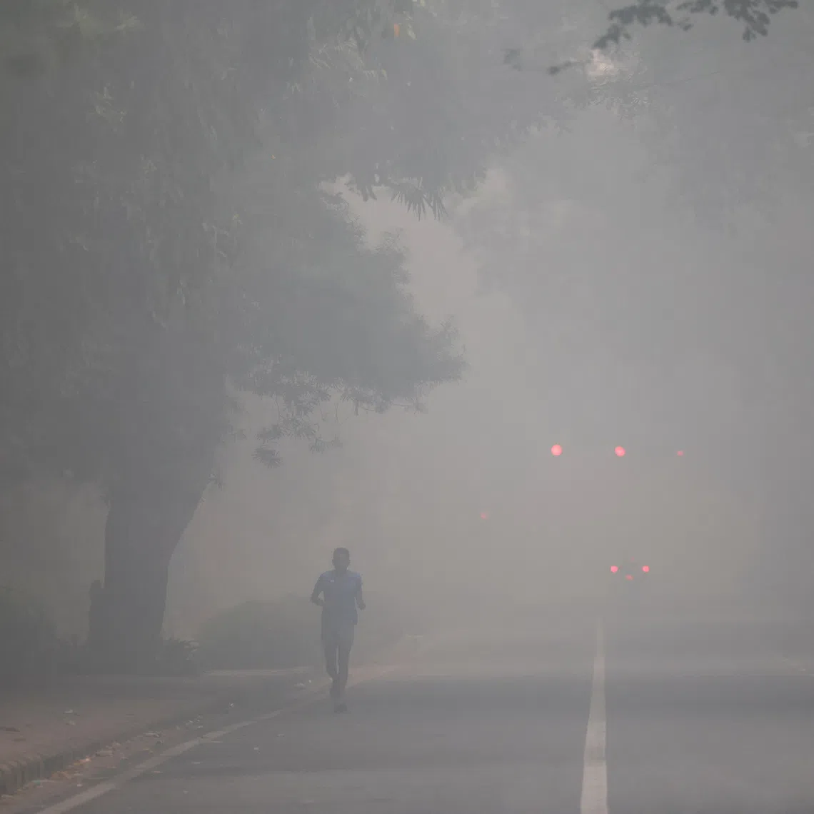 A man jogs on a road shrouded in smog on the day after Diwali, in New Delhi, India, on Oct 21.