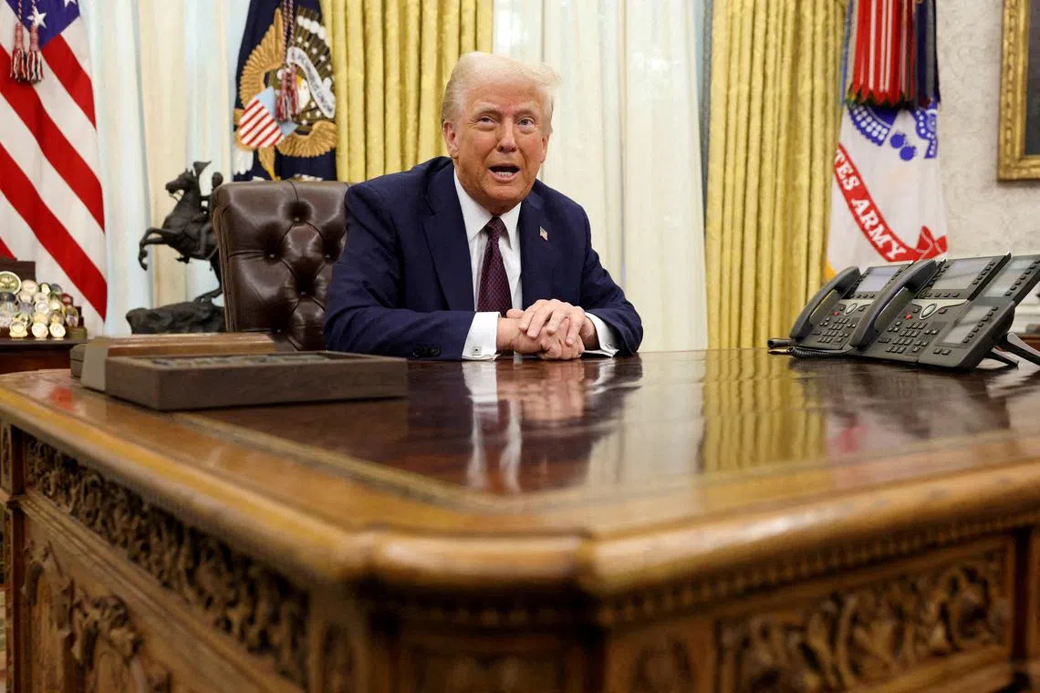 FILE PHOTO: U.S. President Donald Trump sits in the Oval Office of the White House, as he signs executive orders, in Washington, U.S., January 23, 2025.   REUTERS/Kevin Lamarque/File Photo