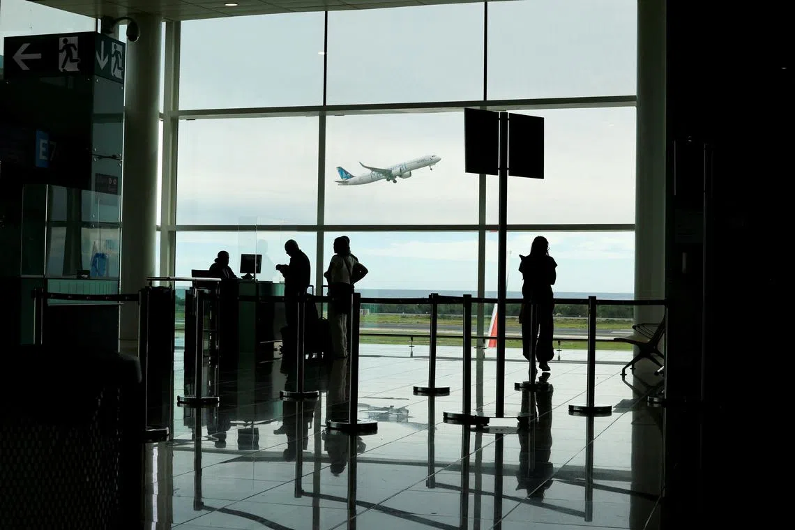 People line up to check in a flight as a plane takes off at Josep Tarradellas Barcelona–El Prat Airport, in Barcelona Spain October 25, 2023. REUTERS/Jorge Silva/File Photo