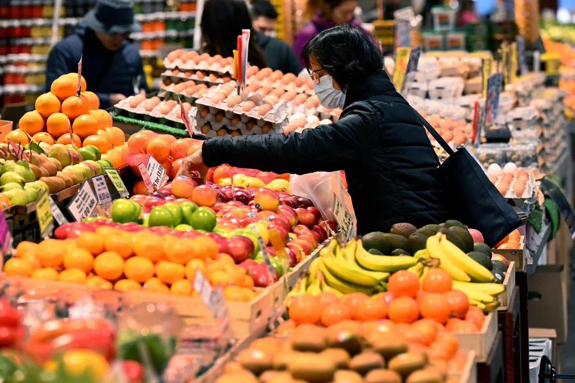 People shop for fresh produce at the Queen Victoria Market in Melbourne. Household budgets in Australia have come under growing pressure as food prices and interest rise. 