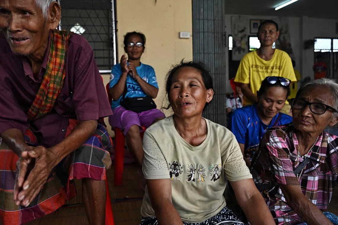 Ms Sai Boonrod (centre) is one of hundreds of Thais sheltering at a temple in the town of Kanthararom after evacuating her border village home.
