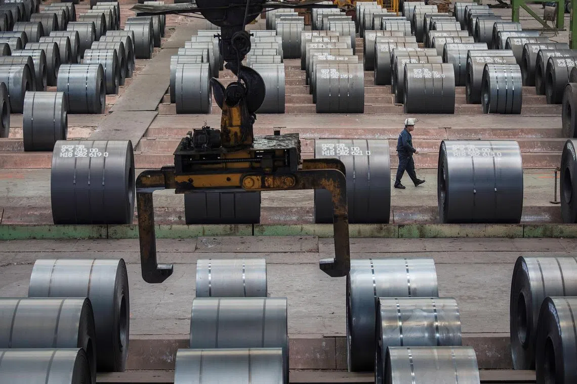 A worker walks past steel rolls at the Chongqing Iron and Steel plant in Changshou, Chongqing, China August 6, 2018. Picture taken August 6, 2018. REUTERS/Damir Sagolj
