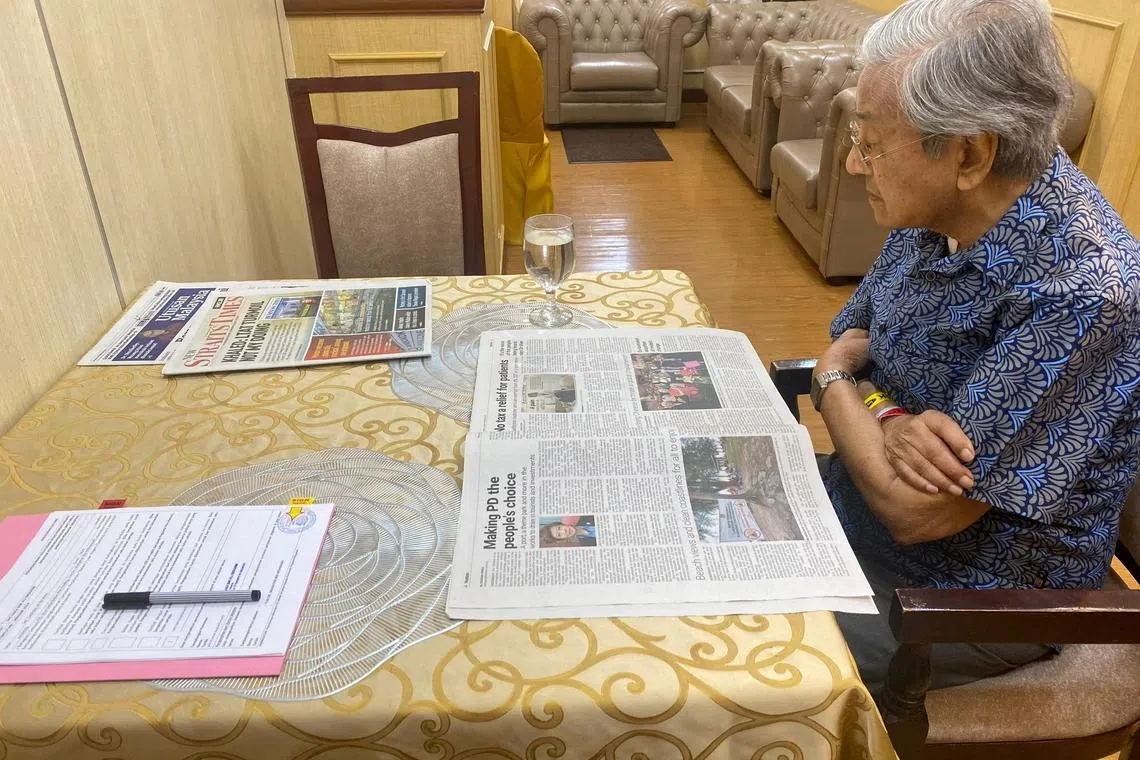 FILE PHOTO: Malaysia's former Prime Minister Mahathir Mohamad reads a newspaper as he is hospitalised for an infection at the National Heart Institute in Kuala Lumpur, Malaysia February 20, 2024. Office of Mahathir Mohamad/Handout via REUTERS/File Photo
