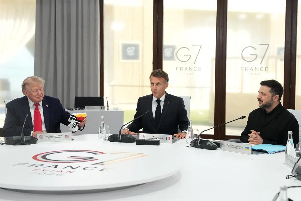 From left, U.S. President Donald Trump, French President Emmanuel Macron and Ukrainian President Volodymyr Zelenskiy during a working session at the G7 summit in Evian-les-Bains, France, June 16, 2026.     Thibault Camus/Pool via REUTERS