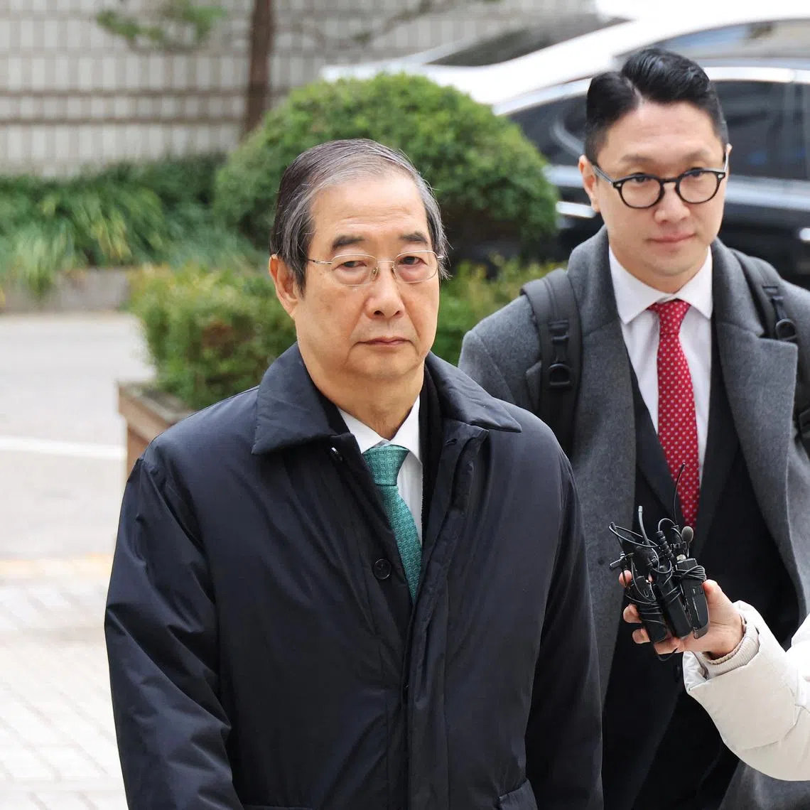 Former Prime Minister Han Duck-soo, who faces charges of allegedly aiding ex-President Yoon Suk Yeol in an attempted insurrection, arrives for closing hearing for his case at the Seoul Central District Court in Seoul, South Korea, November 26, 2025.    REUTERS/Kim Hong-Ji