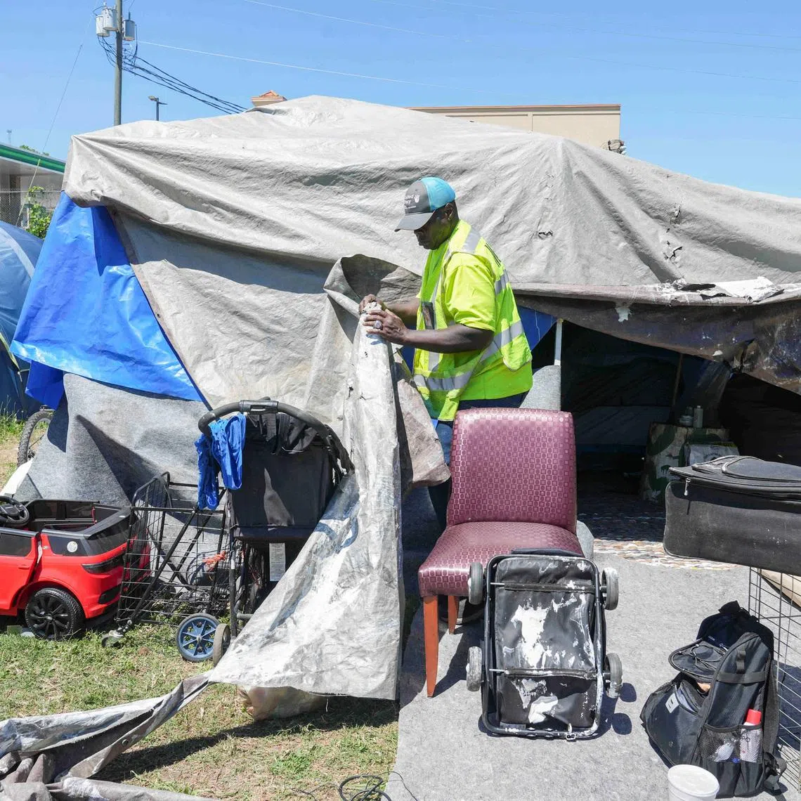 Benjamin Brown, 54, who is currently experiencing homelessness, opens up the tarps to show the inside of his tent in Atlanta, Georgia, U.S., May 15, 2026.   REUTERS/Megan Varner