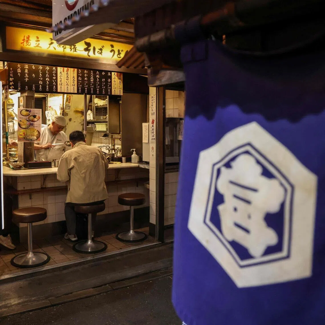 A man eats at an izakaya restaurant in the Shinjuku district in Tokyo on March 30, 2026.