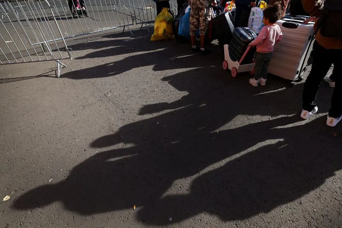 Refugees stand with their luggage at the first reception center for refugees in Giessen, Germany, October 11, 2023. REUTERS/Kai Pfaffenbach/File Photo