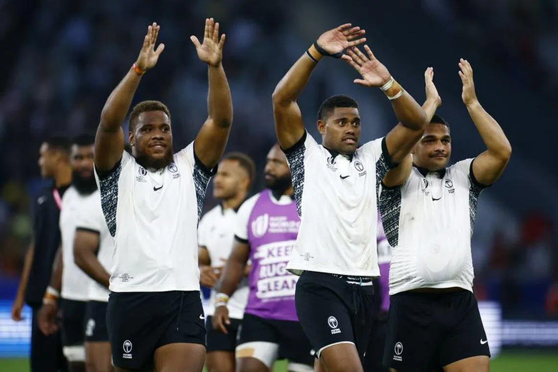 Rugby Union - Rugby World Cup 2023 - Pool C - Australia v Fiji - Stade Geoffroy-Guichard, Saint-Etienne, France - September 17, 2023  Fiji's Tevita Ikanivere, Ilaisa Droasese and Samuel Matavesi celebrate after the match REUTERS/Sarah Meyssonnier