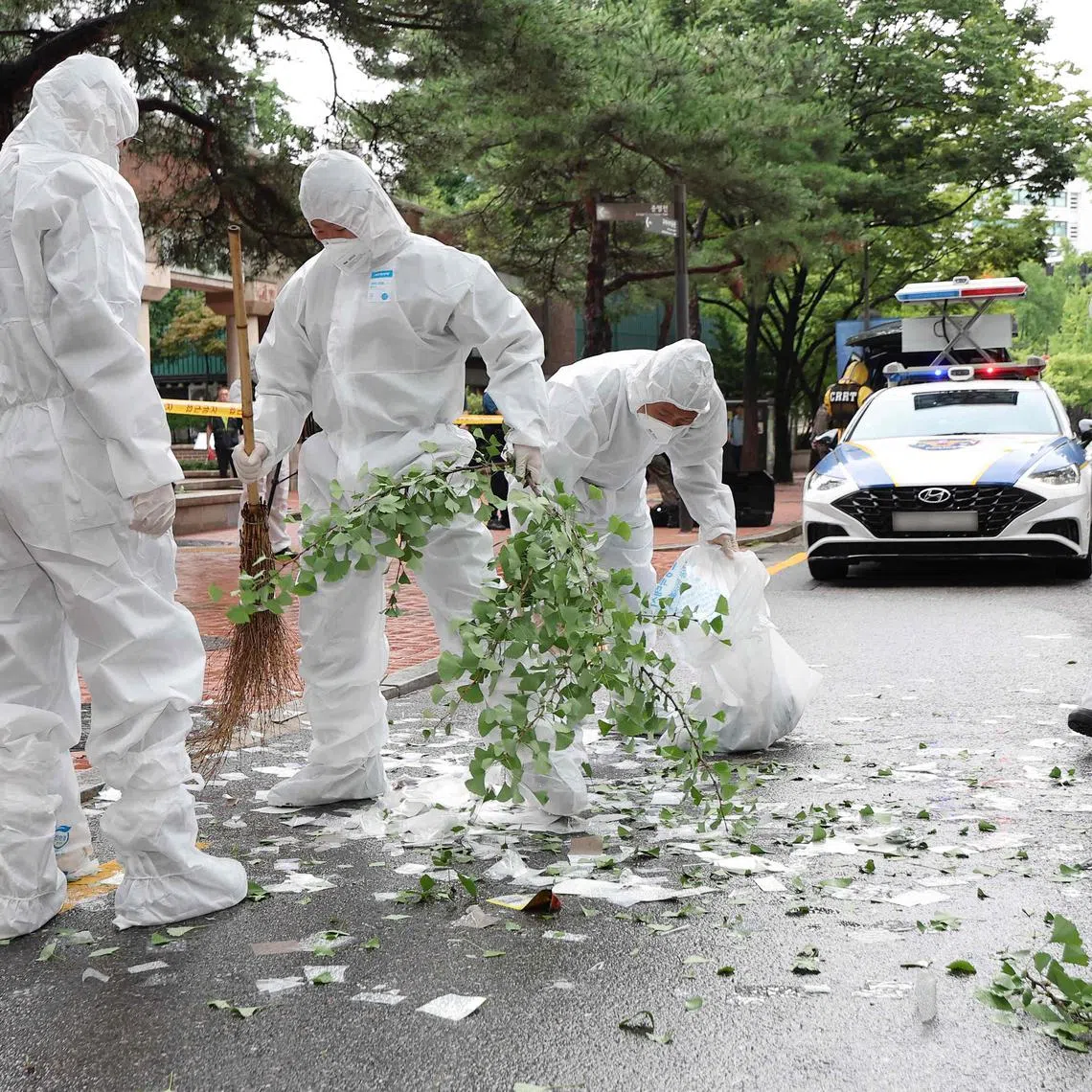 South Korean officials clean up the contents of a trash-carrying balloon sent by North Korea after it landed on a street in Seoul on July 24.