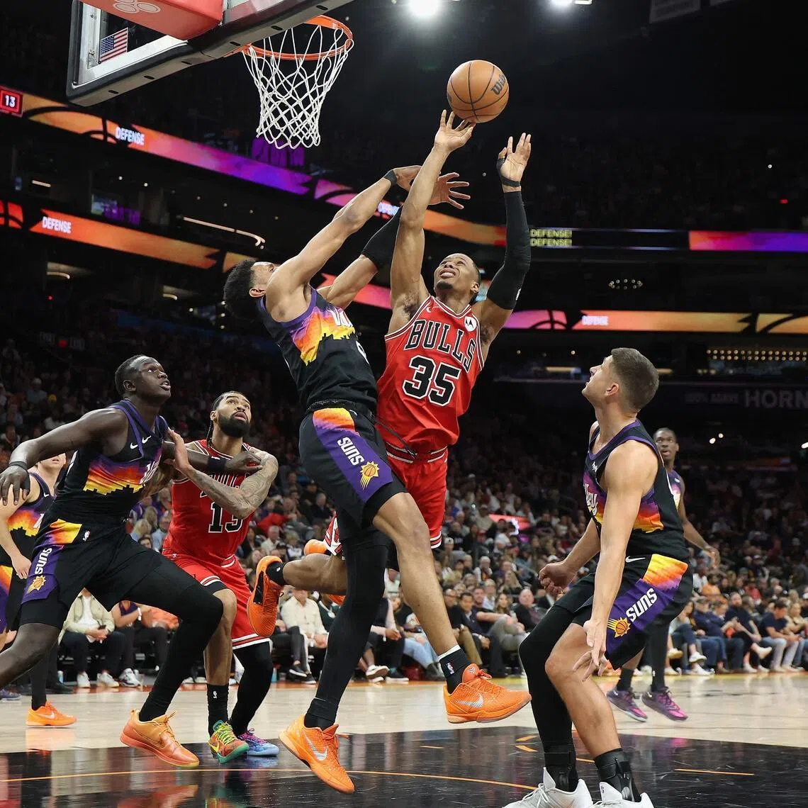 Isaac Okoro of the Chicago Bulls attempts a shot against Ryan Dunn of the Phoenix Suns during the second half of the NBA game at Mortgage Matchup Center.