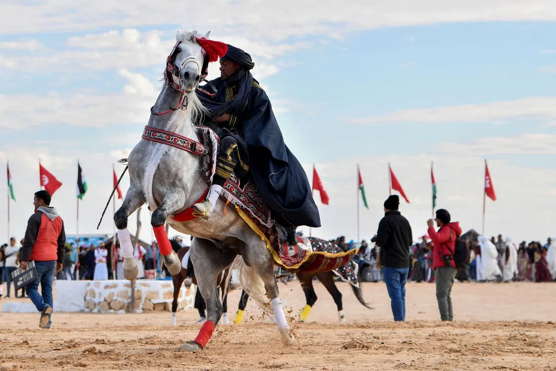 A performer wearing traditional outfit riding a horse at the start of the International Sahara Festival on Dec27, 2023 in Douz, in southern Tunisia. 