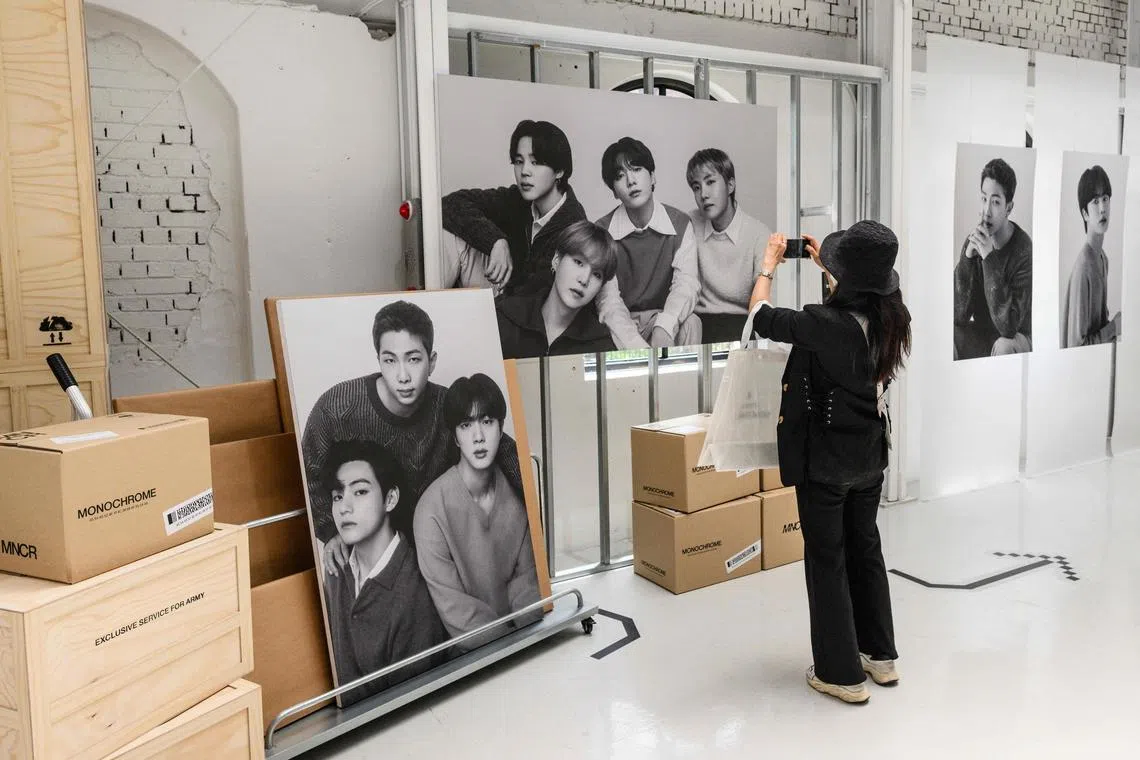A fan takes photos as she visits a pop-up store that will be open until May 12 of South Korean K-pop sensation BTS entitled "Monochrome" in Seoul on April 26, 2024. (Photo by ANTHONY WALLACE / AFP)