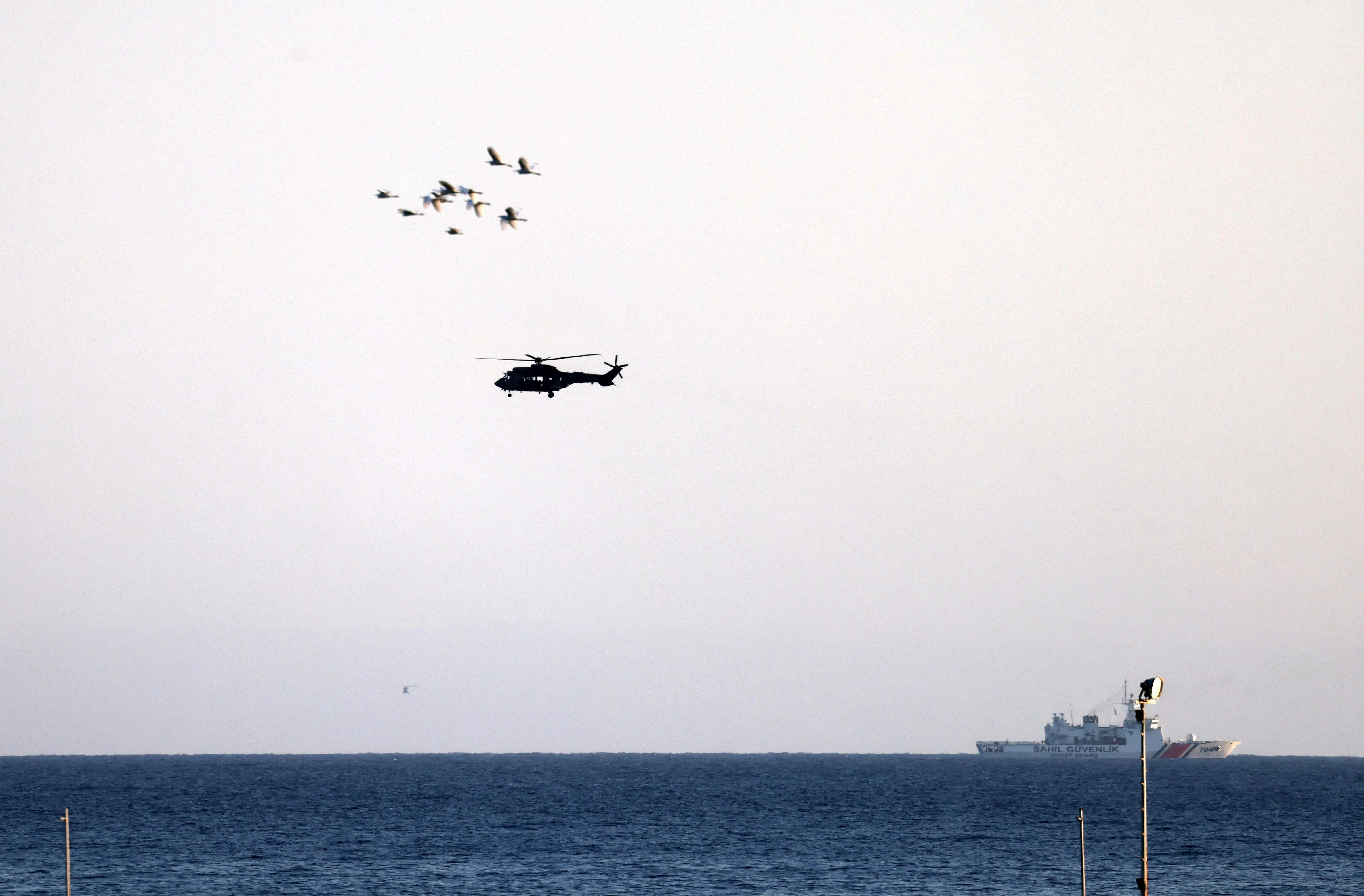 A helicopter and a vessel operating near the area where a ferry capsized off the coast of Kyrenia, in Turkish-controlled northern Cyprus, on Aug 31.