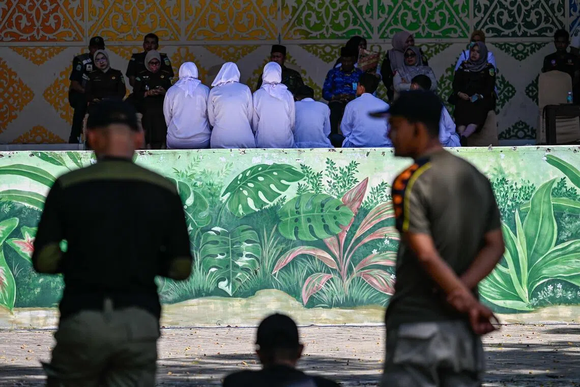 People deliver a speech before a public caning by members of the syariah police in Banda Aceh on Jan 29.