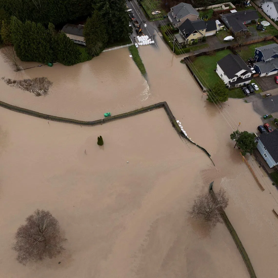 A drone view shows the failure of a temporary flood barrier along the White River, after multiple atmospheric rivers brought rain and flooding to the Pacific Northwest, in Pacific, Washington, U.S., December 16, 2025.  REUTERS/David Ryder