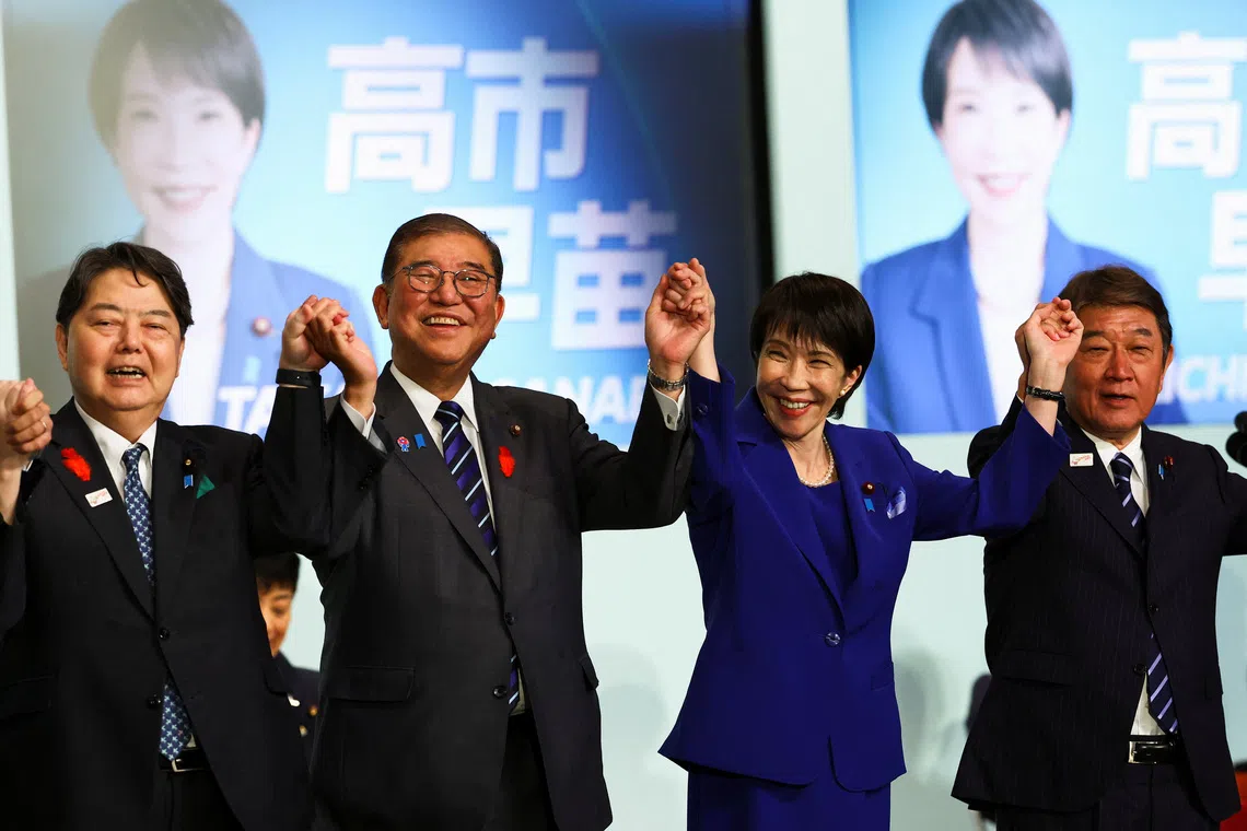Newly-elected leader of Japan's Liberal Democratic Party (LDP) Sanae Takaichi celebrates with Prime Minister Shigeru Ishiba and other leadership candidates, Japan's Chief Cabinet Secretary Yoshimasa Hayashi and former Foreign Minister Toshimitsu Motegi, after winning the LDP leadership election in Tokyo, Japan, October 4, 2025. REUTERS/Kim Kyung-Hoon/Pool