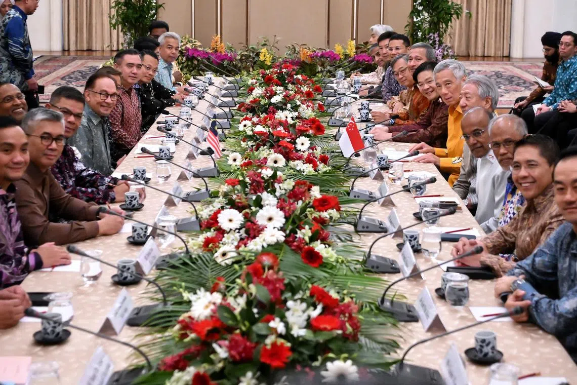 PM Lee Hsien Loong (sixth from right) and Malaysian PM Anwar Ibrahim (fifth from left) with the ministers from both countries at a delegation meeting at the Istana on Oct 29, 2023.