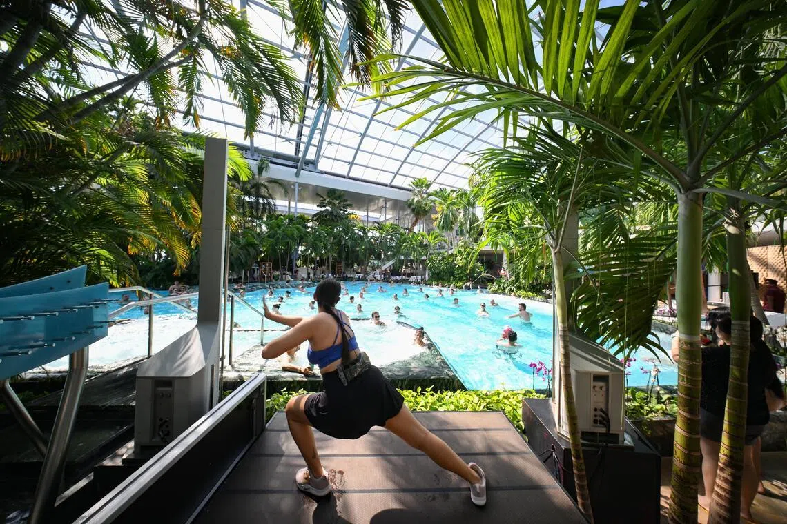 Visitors following an instructor-led aqua exercise inside the main pool at Therme Bucharest in Romania.
