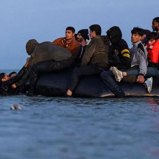 Migrants try to board a smuggler's boat in an attempt to cross the English Channel off the beach of Gravelines, northern France.