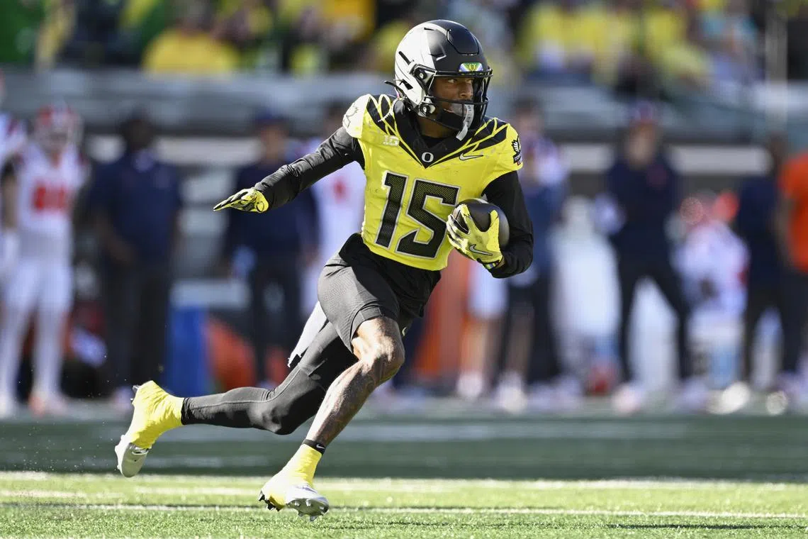 Oct 26, 2024; Eugene, Oregon, USA; Oregon Ducks wide receiver Tez Johnson (15) catches a pass for a touchdown during the first half against Illinois Fighting Illini defensive back Xavier Scott (14) at Autzen Stadium. Mandatory Credit: Troy Wayrynen-Imagn Images/File Photo