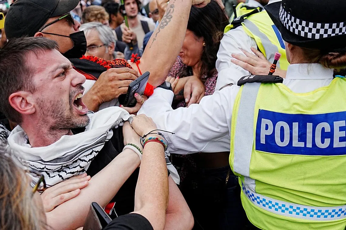 FILE PHOTO: A man reacts as police officers operate during the \"Lift The Ban\" rally organised by Defend Our Juries, challenging the British government's proscription of \"Palestine Action\" under anti-terrorism laws, in Parliament Square, in London, Britain, September 6, 2025. REUTERS/Carlos Jasso/File Photo