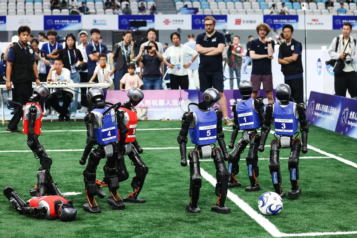 Humanoid robots playing soccer during the World Humanoid Robot Games at the National Speed Skating Oval in Beijing, China, on Aug 15 2025. 