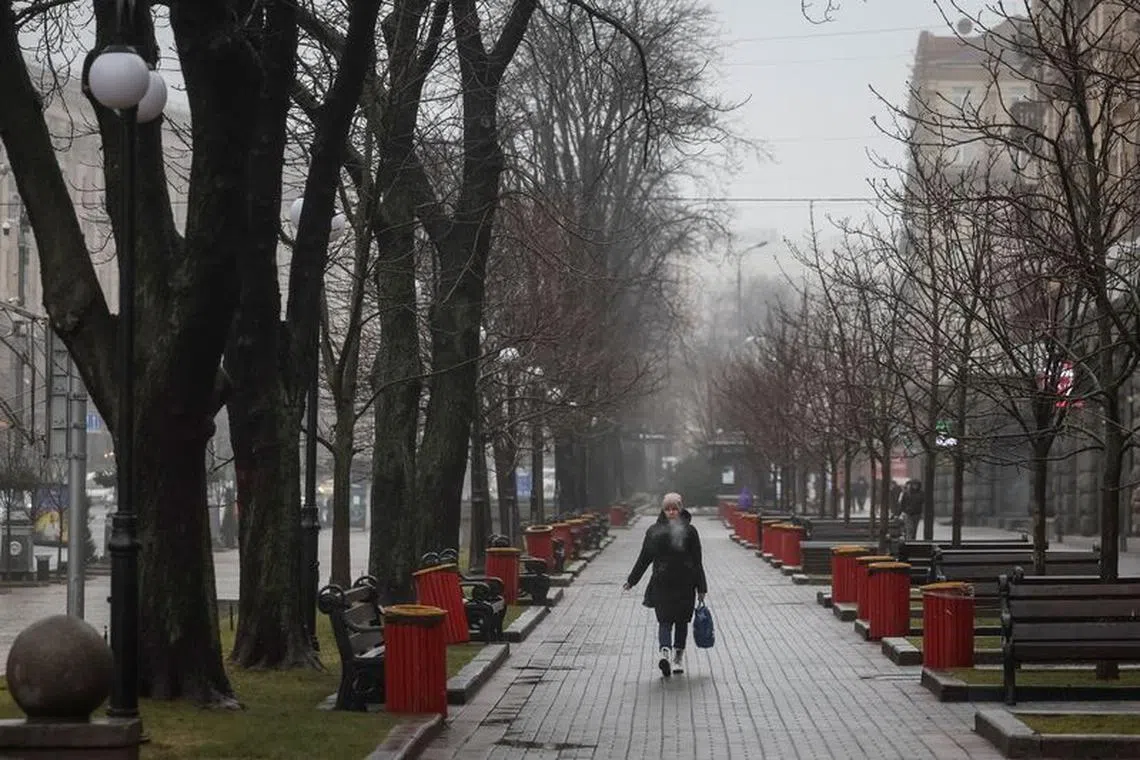A woman smokes as she walks on the main street Khreshchatyk, amid Russia's attack on Ukraine, in central Kyiv, Ukraine February 14, 2024. REUTERS/Gleb Garanich