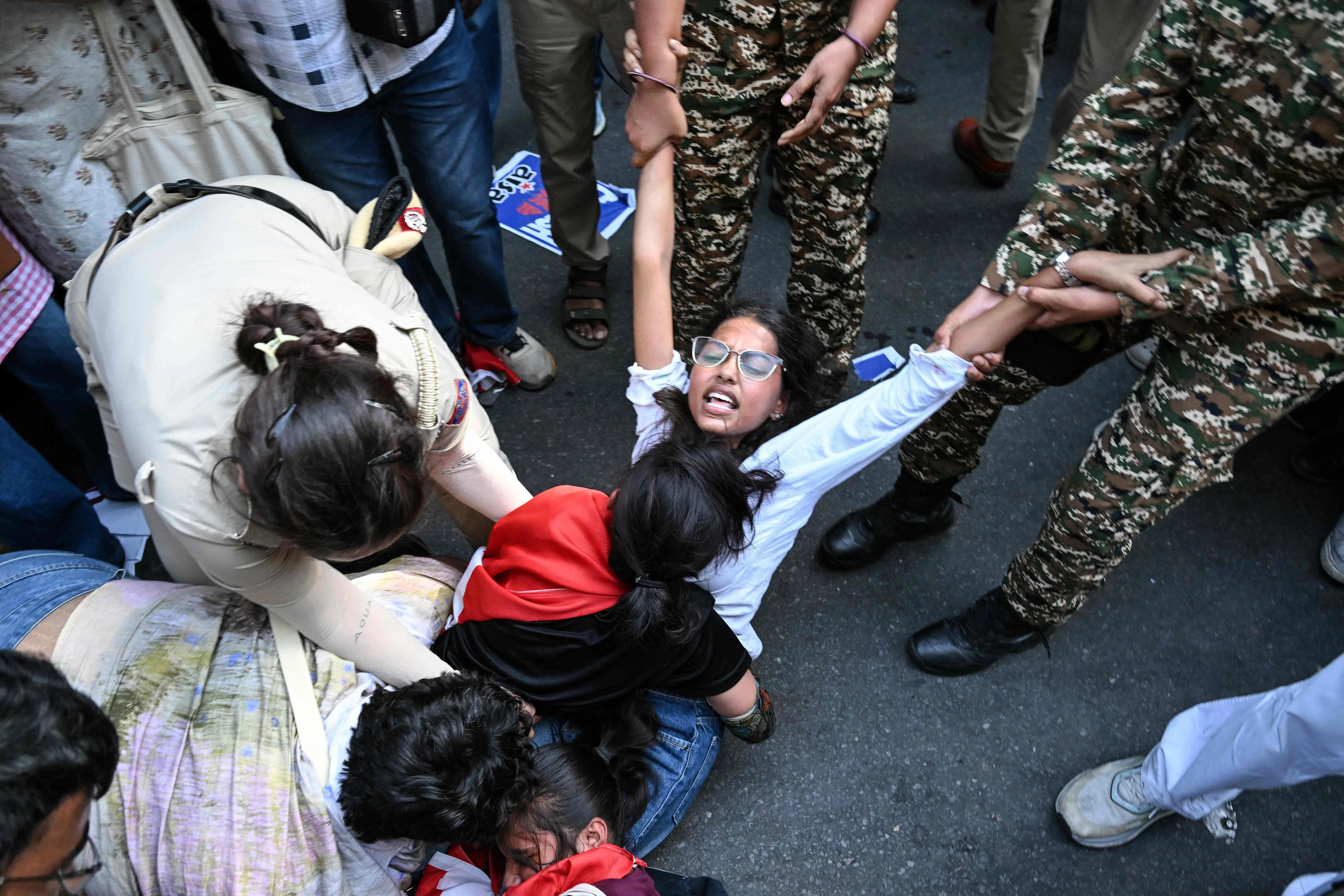 Police and security personnel detaining a protester during the demonstration in New Delhi on Oct 3.