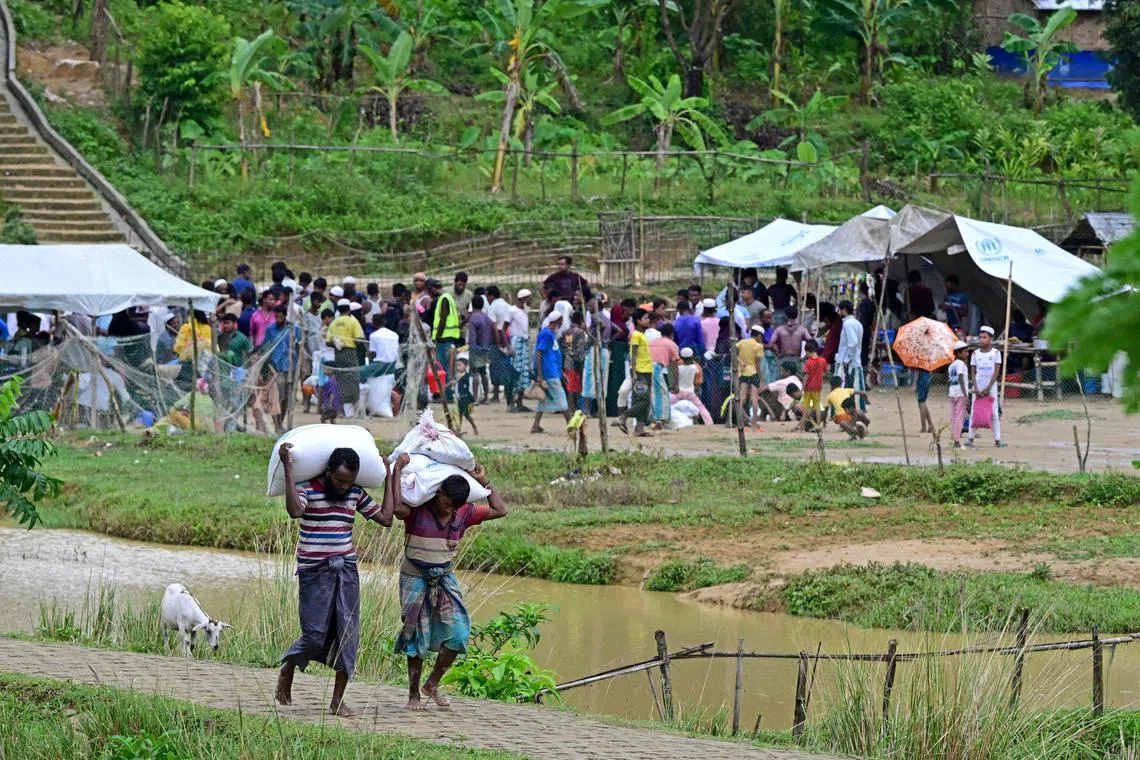 In this photo taken on September 12, 2024, Rohingya refugees gather to collect relief material at a camp in Ukhia. Around a million members of the stateless and persecuted Muslim minority live in a sprawling patchwork of Bangladeshi relief camps after fleeing violence in their homeland next door. Hasina was lauded by the international community in 2017 for opening the borders to around 750,000 Rohingya who fled a Myanmar military crackdown that is now the subject of a UN genocide investigation. (Photo by Munir UZ ZAMAN / AFP) / TO GO WITH: Bangladesh-Myanmar-conflict-refugee-Rohingya, FOCUS by Mohammad MAZED and Tanbirul Miraj RIPON
