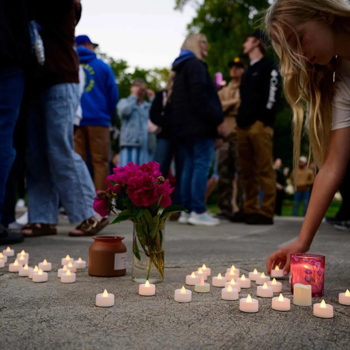 Community members place electric candles near a vase of flowers during a vigil following a fatal chemical storage tank failure on May 26, 2026, in Longview, Washington.
